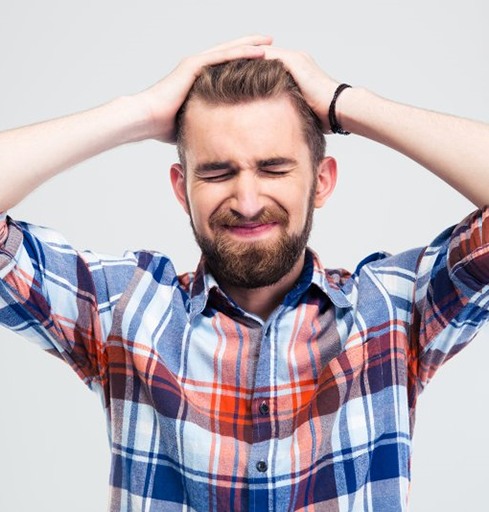 a man holding his head due to anger