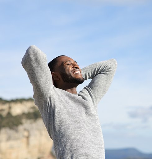 Calm, happy man standing outside