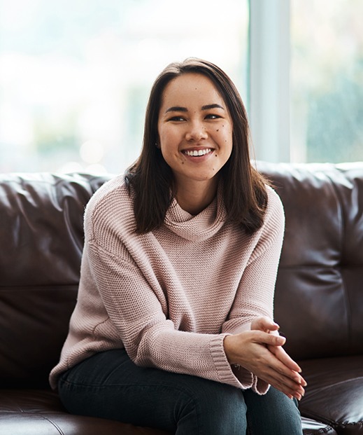 Happy woman sitting on couch, speaking to her therapist