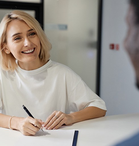 Woman filling out paperwork at medical office front desk