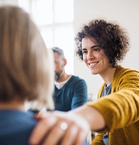 smiling woman talking to woman with depression