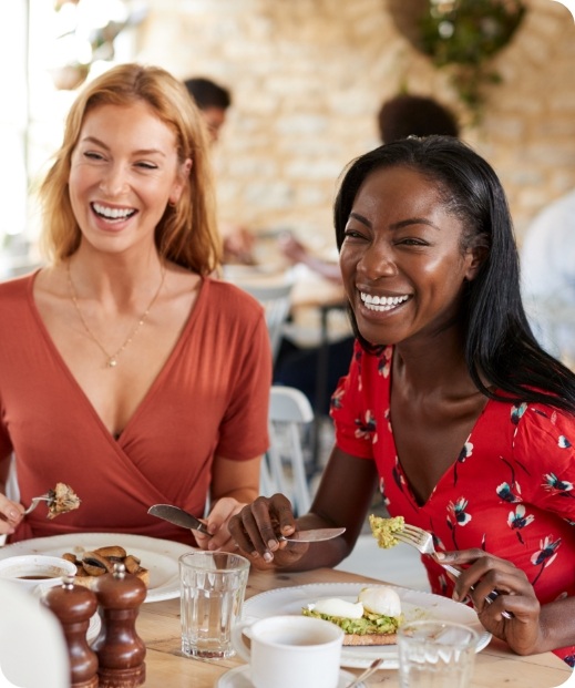 two women smiling at lunch