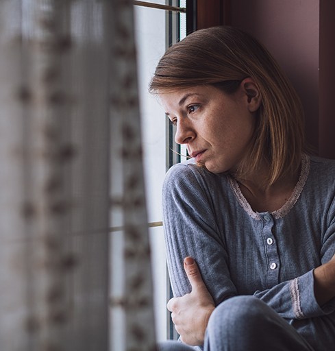 Sad woman looking out her window