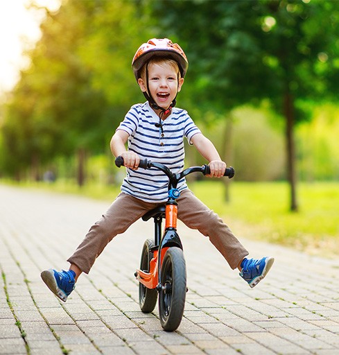 Happy boy playing outside on his bike