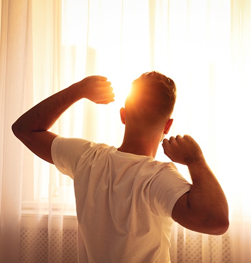 Man stretching after night of good sleep