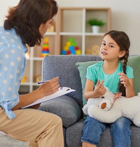 Mental health professional listening to child during therapy