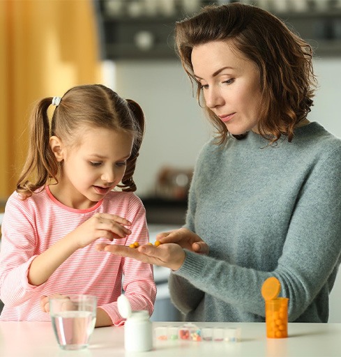 Mother helping her daughter with medications