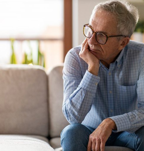 a man sitting on the couch and looking worried