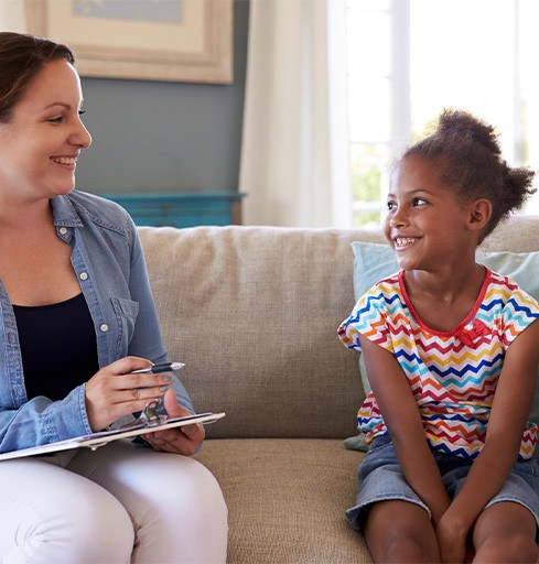 Smiling child talking to mental health professional