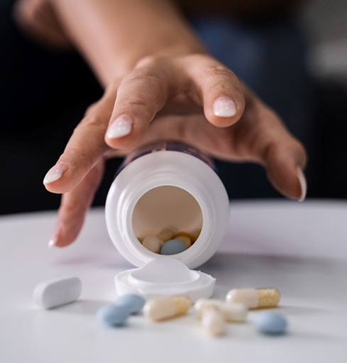 Person’s hand reaching for pills