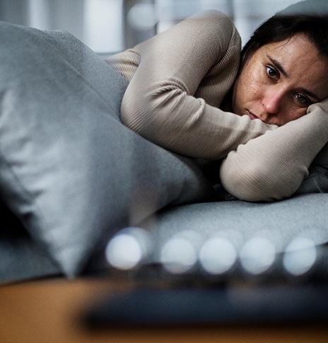 young woman laying in bed with depression 