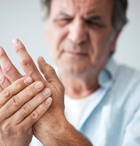 man with chronic pain holding hand 