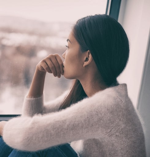 Woman gazing out the window before treatment for post partum depression