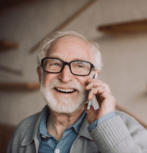 Man on phone smiling thanks to treatment for post traumatic stress disorder