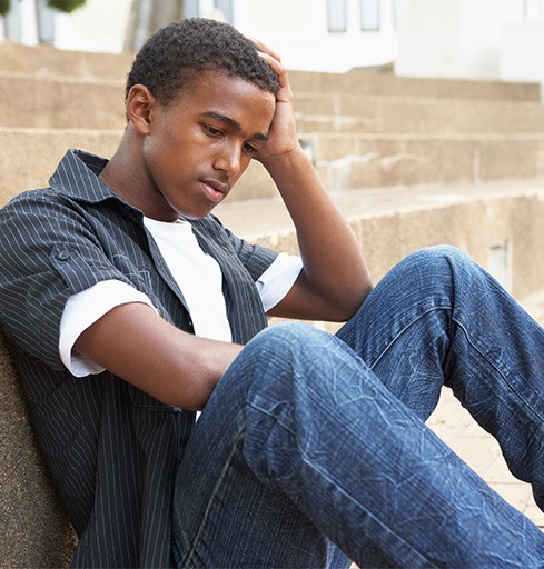 depressed teen boy sitting outside v1