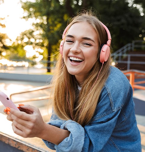 smiling teen girl holding her phone v1